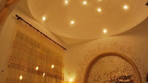 A bedroom with a large bed, a decorative ceiling, and a wall with a floral pattern. - Baan Aom Kod Kun Kao (Suan Phueng)
