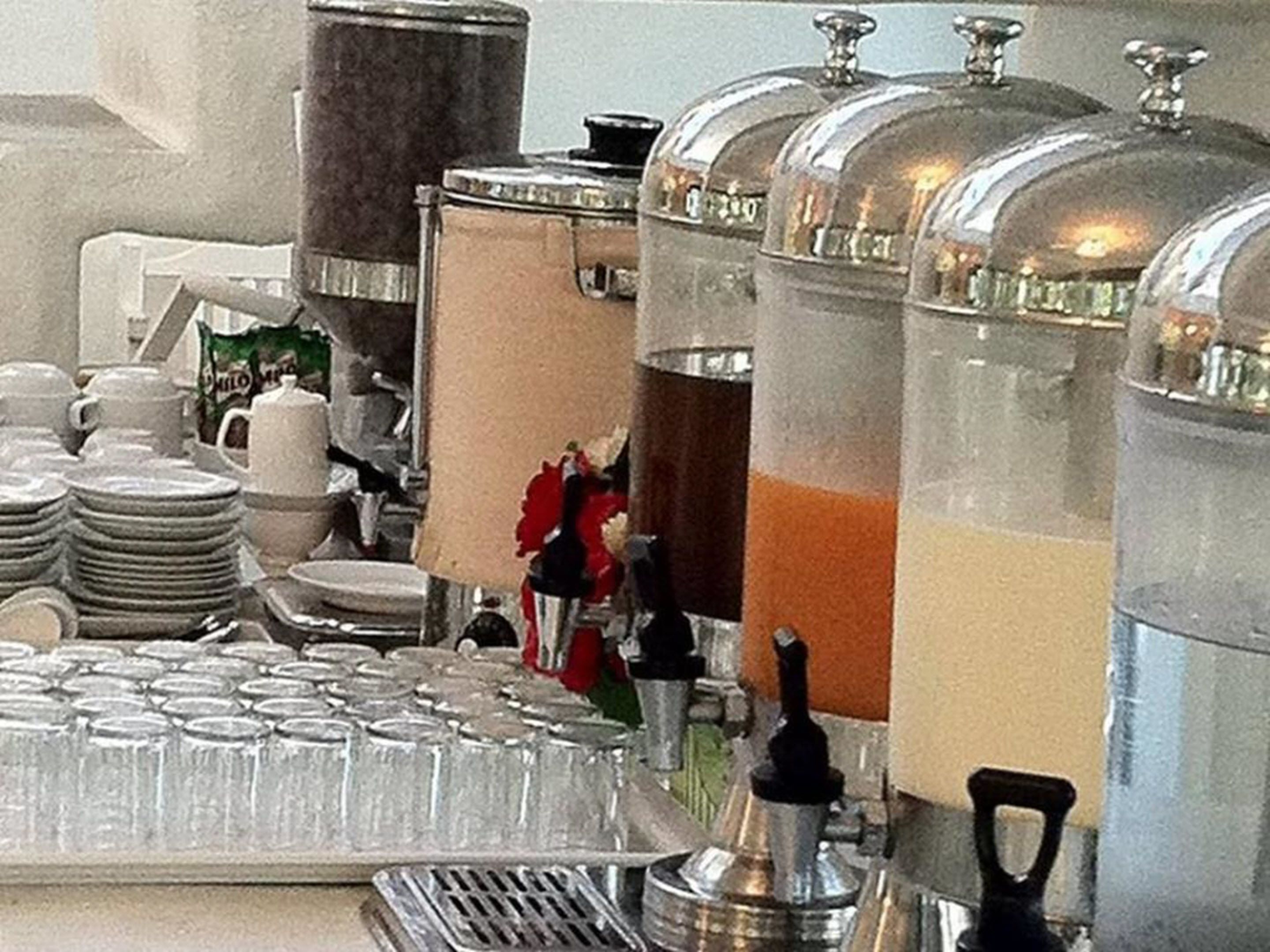 A buffet setup with multiple serving stations, including glassware and plates.