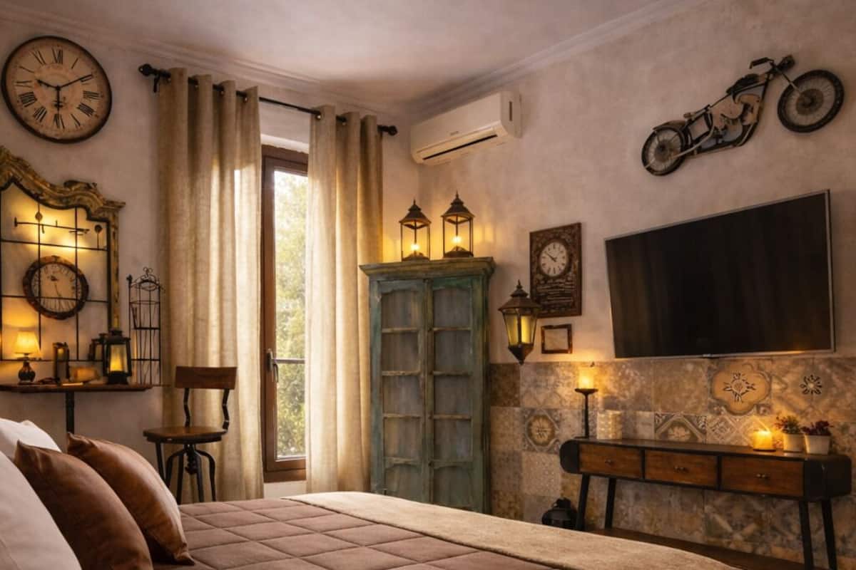 Un dormitorio con una cama grande, un escritorio de madera, un televisor y una bicicleta.
