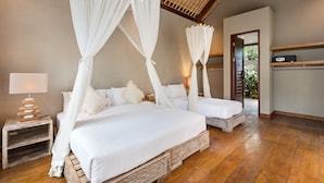 Een slaapkamer met twee bedden, elk voorzien van witte beddengoed en een hemelbed, een nachtkastje met een lamp, en een houten vloer.