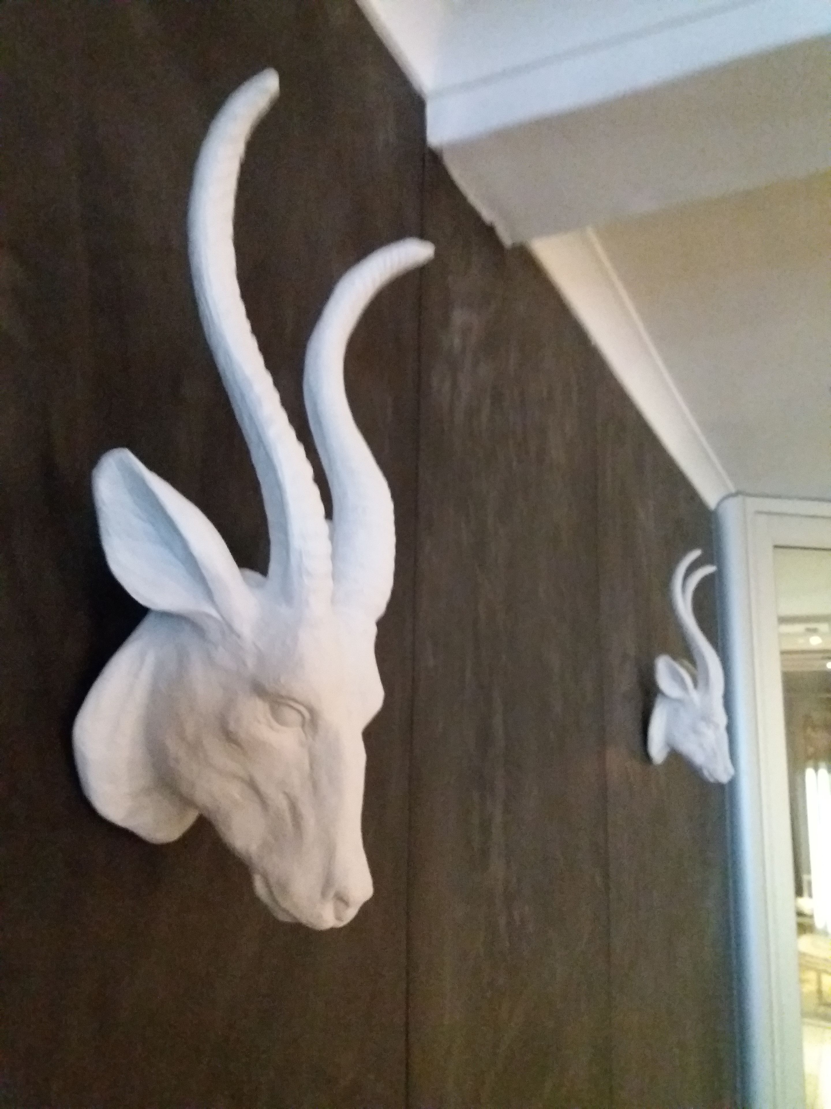 A wall-mounted sculpture of a deer head with antlers.