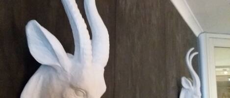 A wall-mounted sculpture of a deer head with antlers.