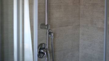 A shower with a handheld showerhead and a wall-mounted faucet.