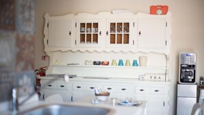 A kitchen with white cabinets, a sink, and a coffee machine. - My Sweet Rome (Rome)