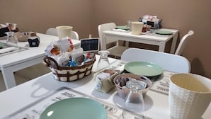 A table set with plates, a basket of snacks, a coffee cup, and a newspaper. - My Sweet Rome (Rome)