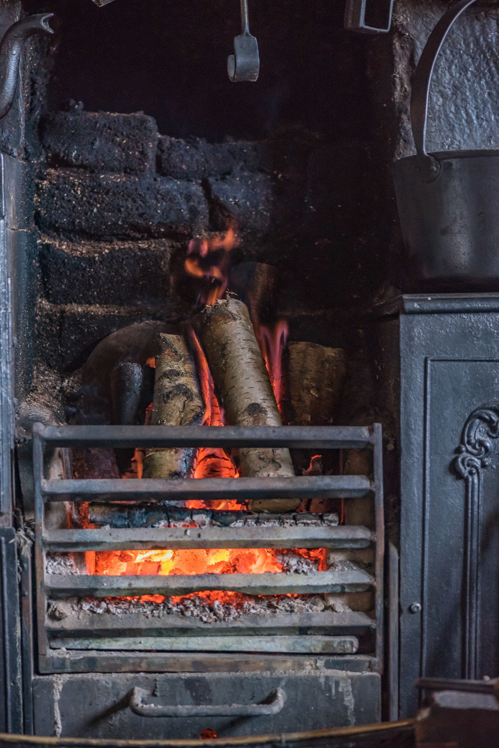 A fireplace with logs burning inside.
