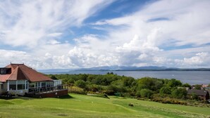 Una casa con un balcón grande que da a un campo de golf y un lago.