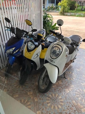 Two scooters parked in front of a building with a tiled floor. - DKaYa Hostel (Takua Pa)