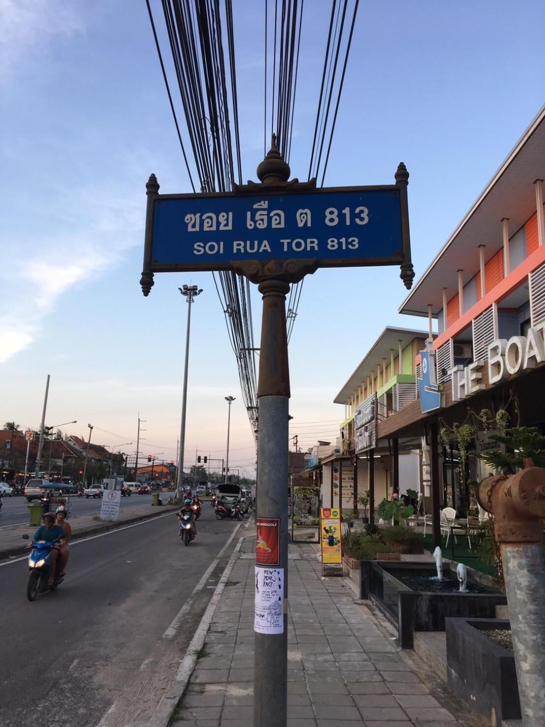 A street sign with 'SOI RUA TOR 813' indicating a location.