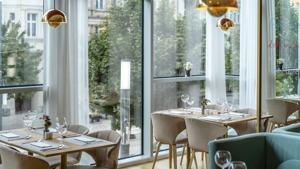Un comedor moderno con ventanas amplias, mesas de madera y asientos cómodos.