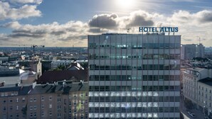 Un edificio de hotel moderno con el nombre "HOTEL ALTUS" bien visible.