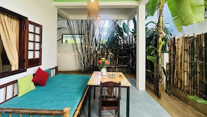 Una habitación con cama, una mesa y sillas, y una lámpara colgante.
