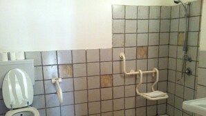 A bathroom with a toilet, a shower, and a grab bar. - Hotel Bella Napoli (Agrigento)