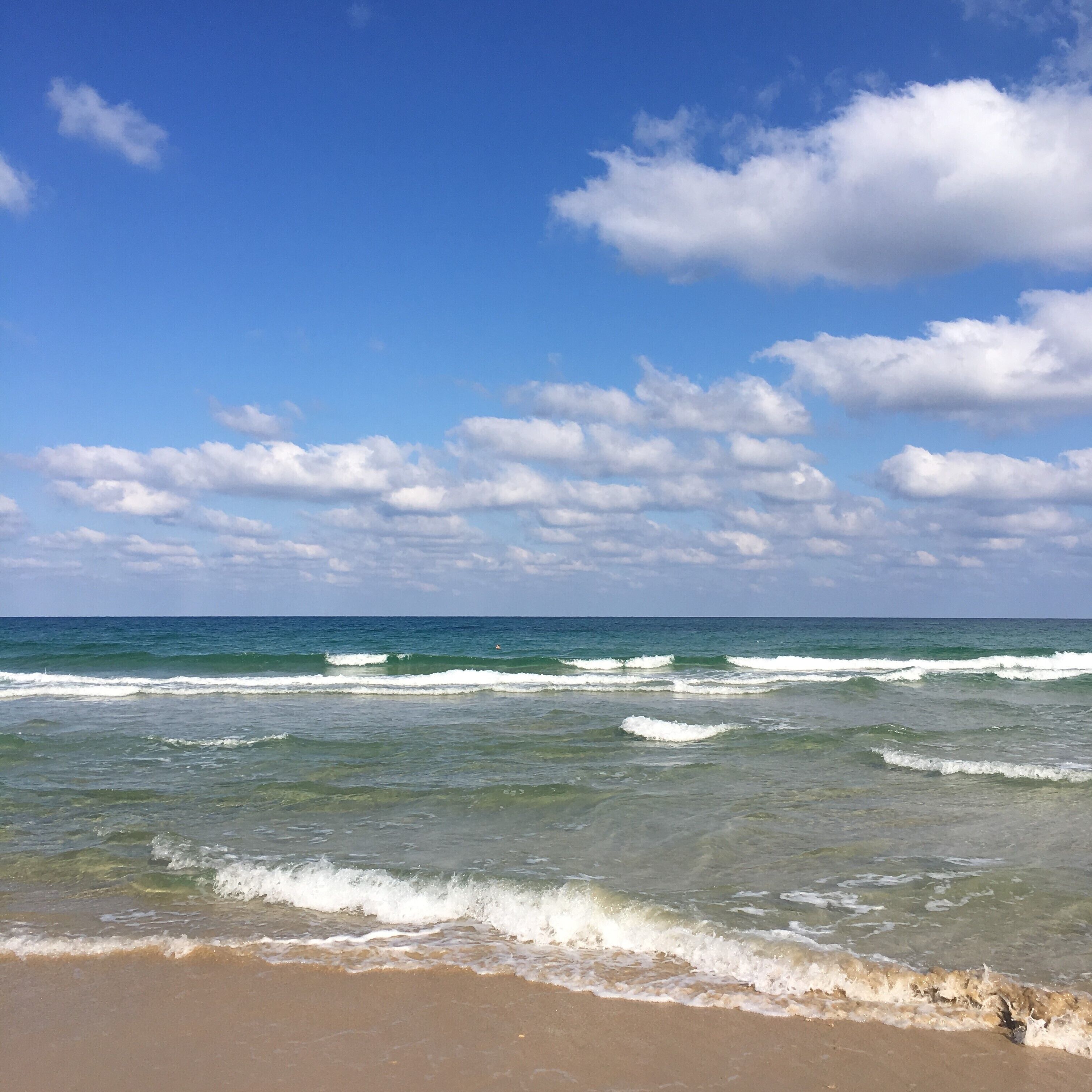 Una playa con olas y cielo despejado.