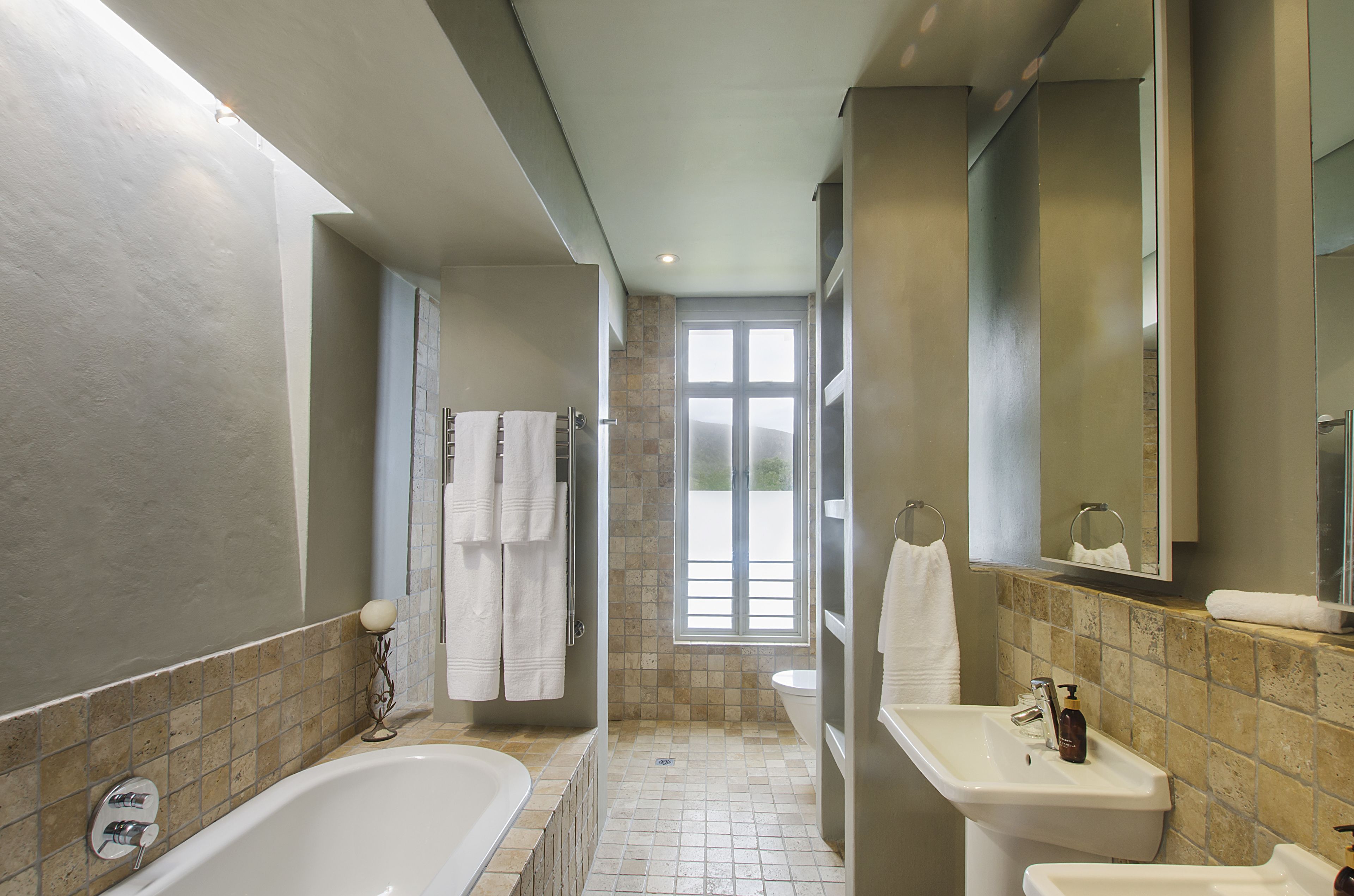 A modern bathroom with a bathtub, sink, and shower area.