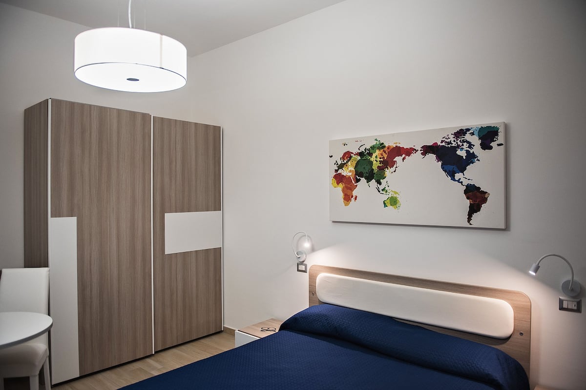 Ein modernes Schlafzimmer mit Bett, Nachttisch und Kleiderschrank.
