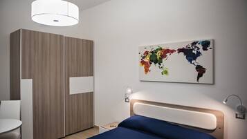 Une chambre à coucher moderne avec un lit, une table de chevet et une armoire.