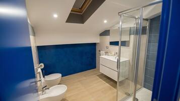 A modern bathroom with a skylight, a glass shower enclosure, and a white sink.