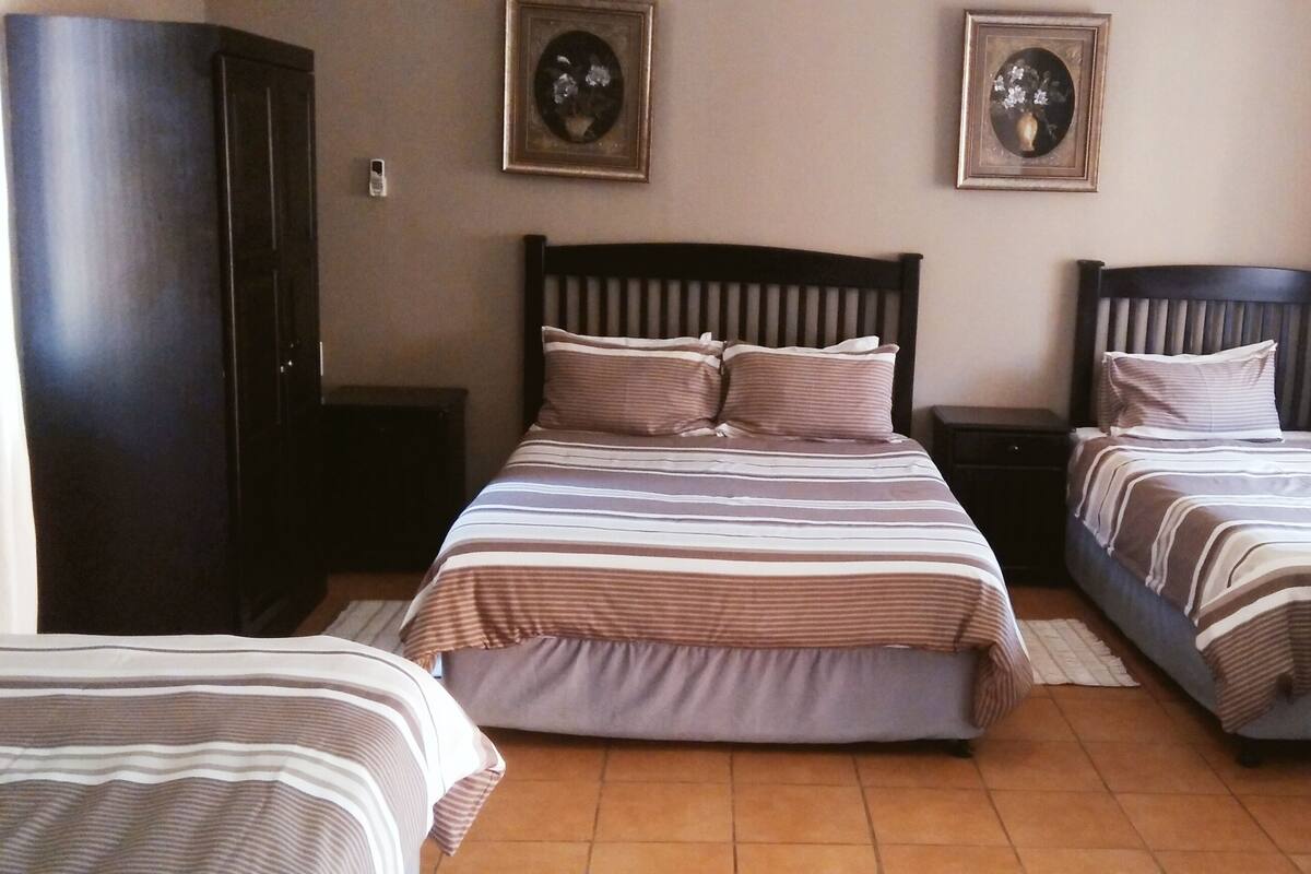 A room with two beds, a wardrobe, and two bedside tables.