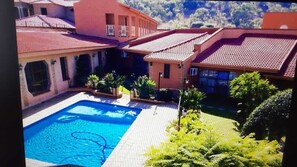 Una piscina al aire libre, sillones reclinables de piscina