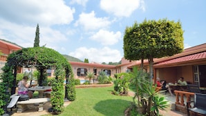 Ein Innenhof mit Pool, Sitzgelegenheiten im Freien und einer Pergola.