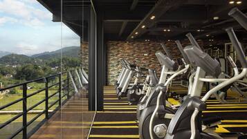 Un gimnasio con bicicletas estáticas y vistas a un paisaje montañoso.