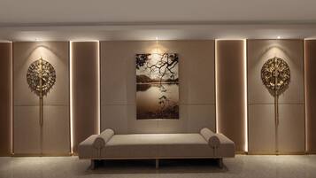 Un interior moderno con un sofá, dos paneles decorativos en la pared e iluminación empotrada.