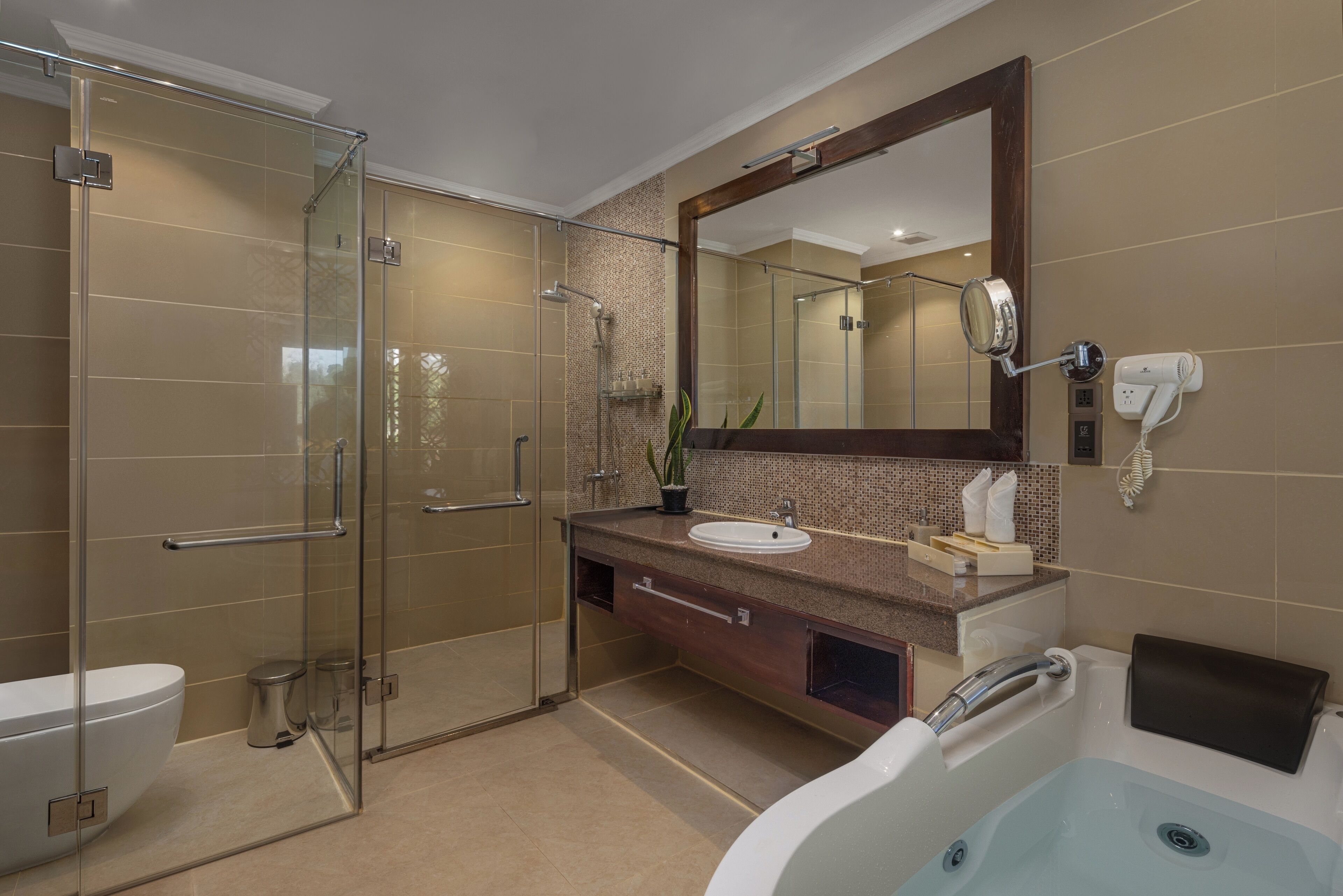 A modern bathroom with a glass-enclosed shower, a white bathtub, a sink with a mirror above it, and a towel rack.