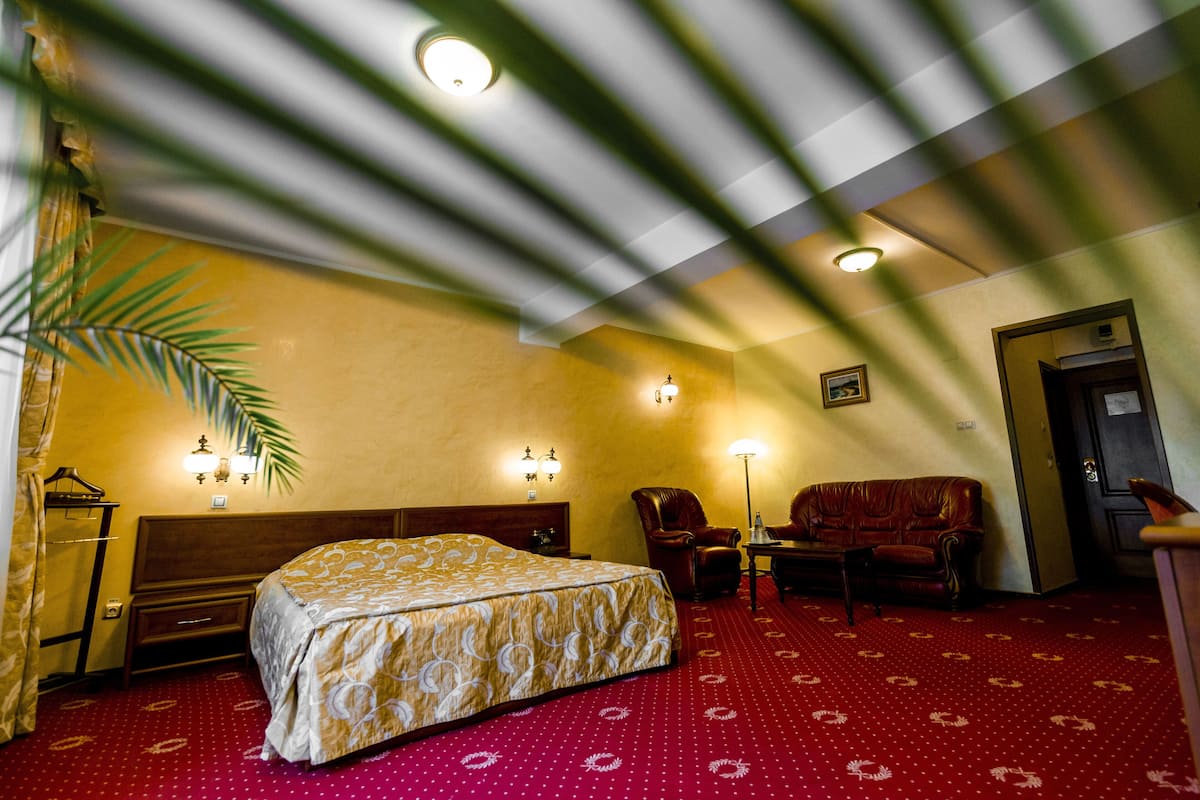 Habitación de hotel con cama, dos sillones, una mesita y un escritorio.