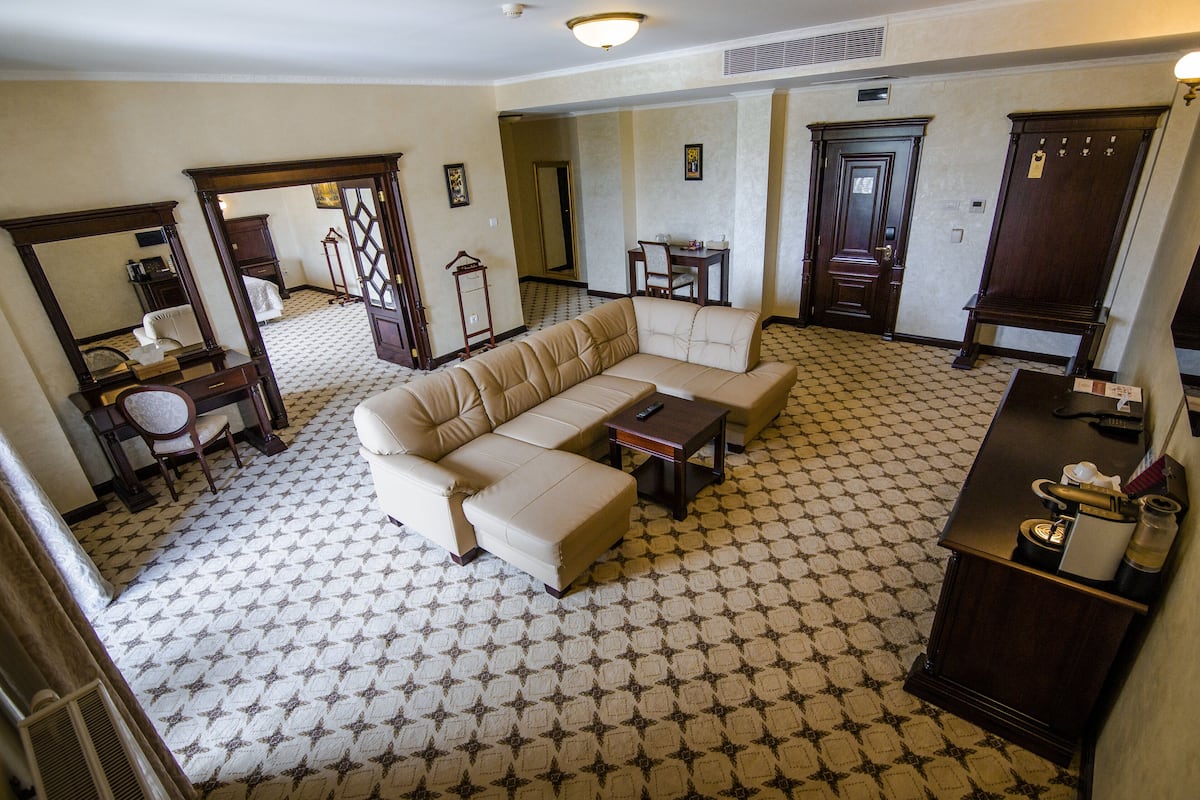 Una sala de estar con suelo estampado, un sofá, una mesa de centro y un escritorio con una silla.