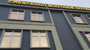 Um edifício com uma placa que diz 'CRESCENDO BOUTIQUE HOTEL'.