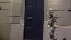 A dark blue door with a doormat reading "WELCOME" in front. - Hostel Lumiere (Milan)