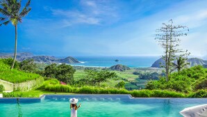 A pool with a view of the ocean and hills. - Selong Selo Resort and Villas (Selong Belanak)