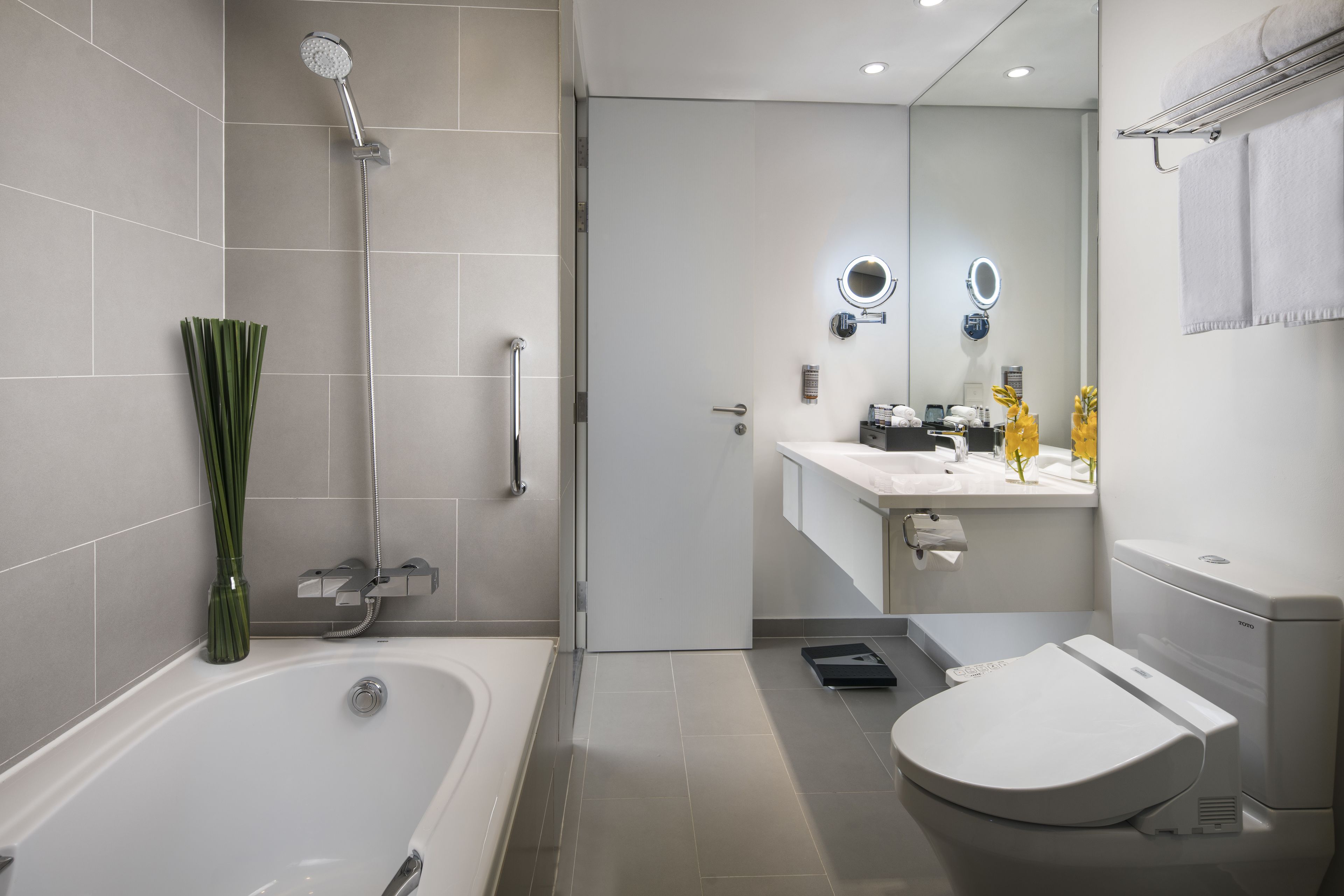 Een moderne badkamer met een bad, toilet en douche.