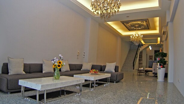 A spacious living area with a modern chandelier, a sofa set, and a coffee table. - Love Paris (Hualien City)