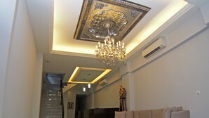 A modern living room with a chandelier, a sofa, and a ceiling with a decorative design. - Love Paris (Hualien City)