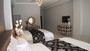 A hotel room with two beds, a mirror, a television, and a decorative table. - Love Paris (Hualien City)