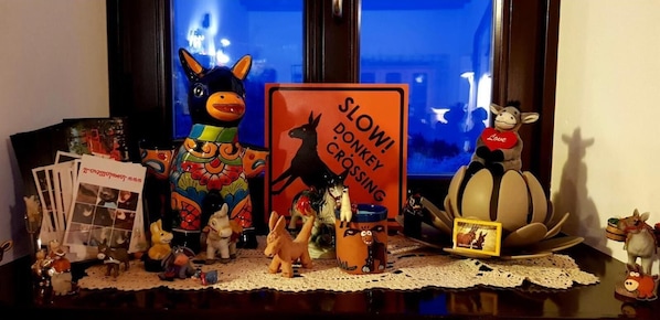 Una colección de figuritas de animales y un cartel con el texto "¡CUIDADO! ZONDA DE PASO DE BURROS" sobre una mesa.
