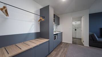 A modern kitchen with grey cabinets, a wooden countertop, and a hanging wooden hanger.