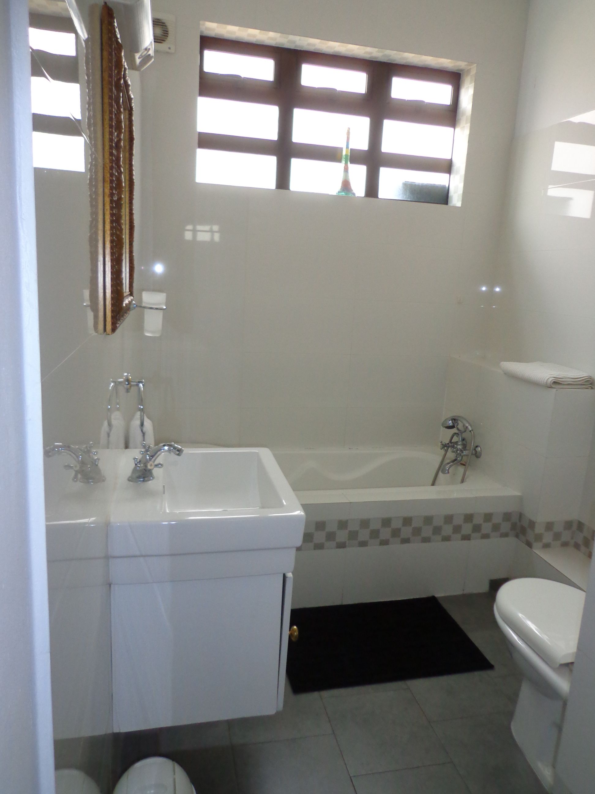 Een badkamer met bad, wastafel en toilet.