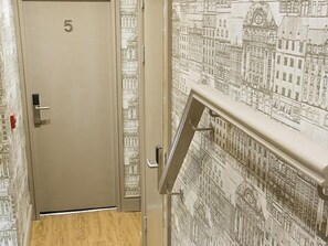 A hallway with a door labeled '5' and a wall with a detailed architectural mural. - Arthur's of Churchtown (Southport)
