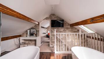 A spacious bathroom with two white tubs, a wooden ceiling, and a patterned wall.