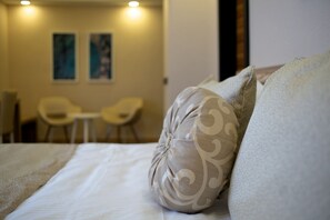 Una habitación de hotel con una cama, dos sillas y una mesita.