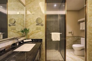 Ein modernes Badezimmer mit Marmorwaschtisch, einer Duschkabine und einer Toilette.