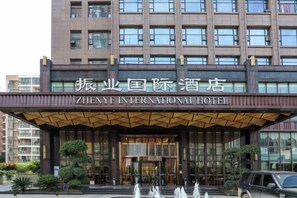 The entrance of the Zhenye International Hotel with a prominent sign above the entrance and a fountain in front. - Zhenye International Hotel (Wuhan)