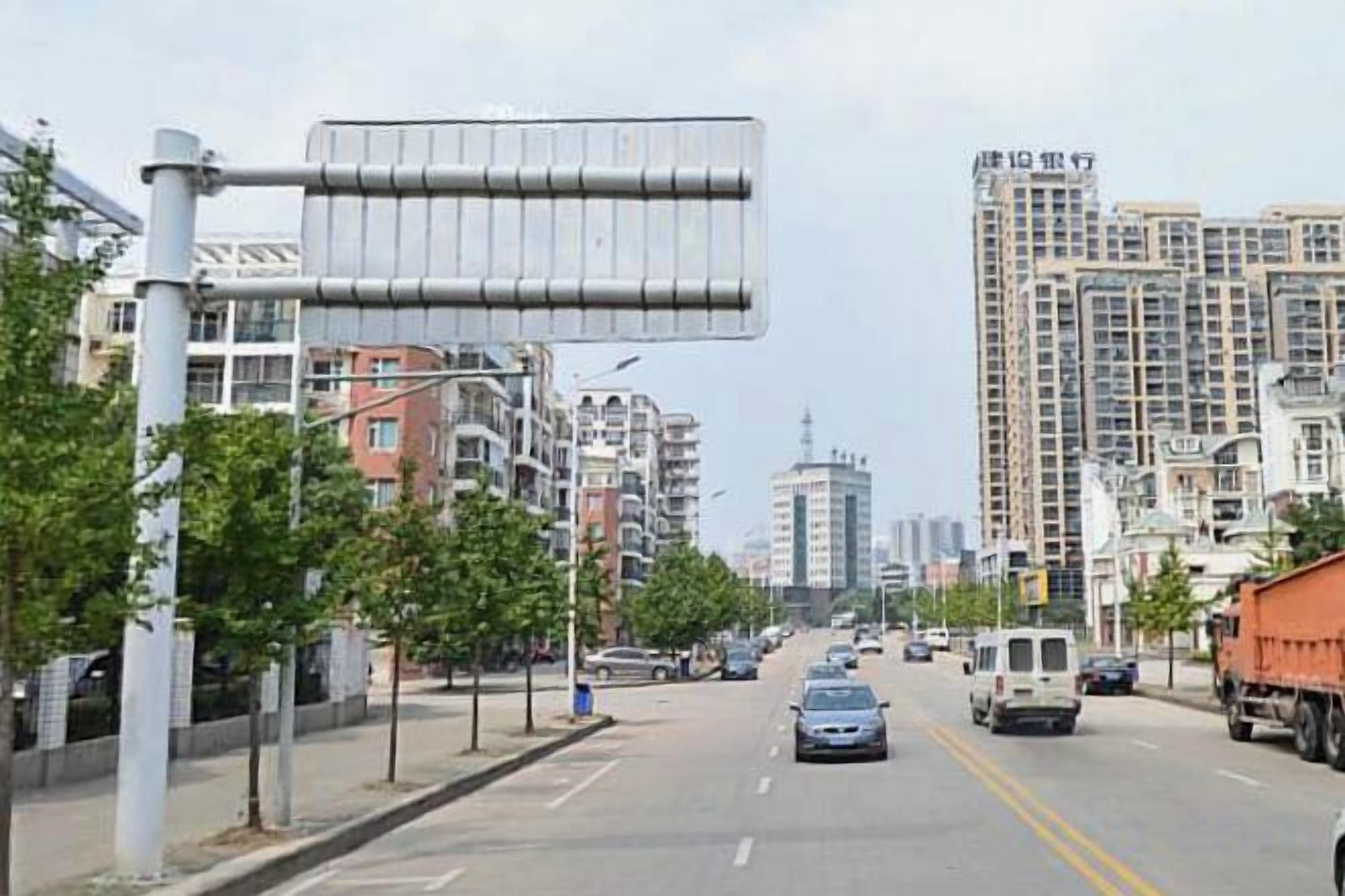 A city street with buildings, a road, and vehicles.