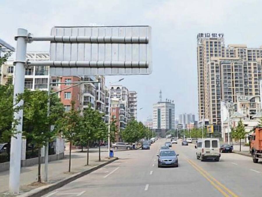 A city street with buildings, a road, and vehicles.