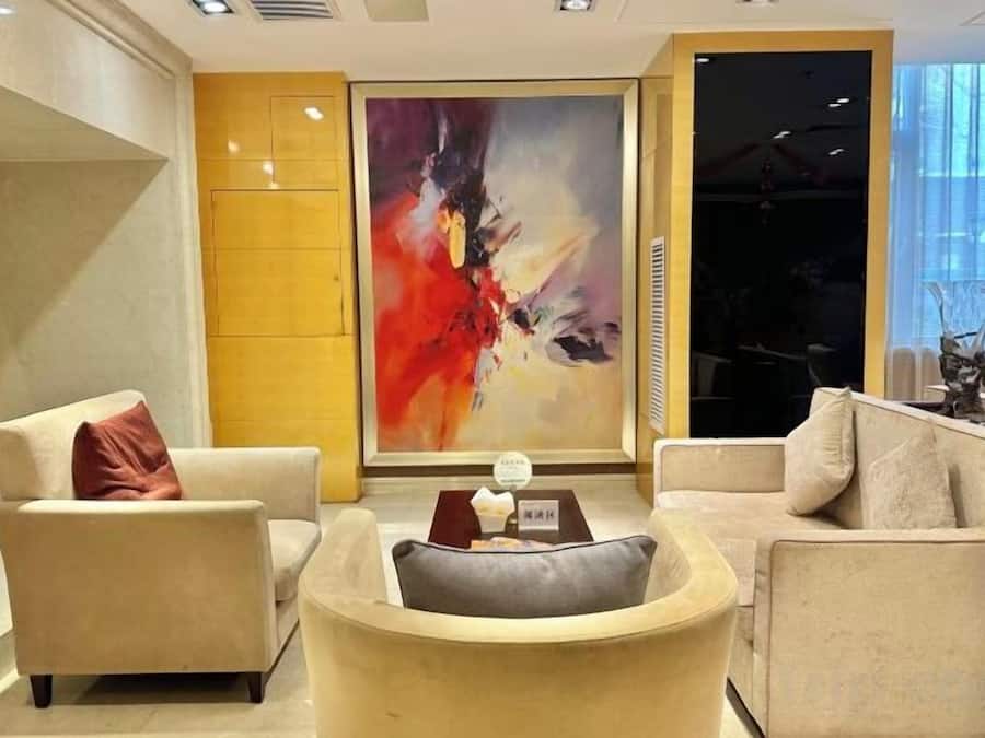 A modern living room with a large abstract painting, a sofa, and a coffee table.