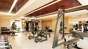 A modern gym with various exercise equipment, including dumbbells, weight machines, and cardio machines. - Eaself Hotel (Beijing)