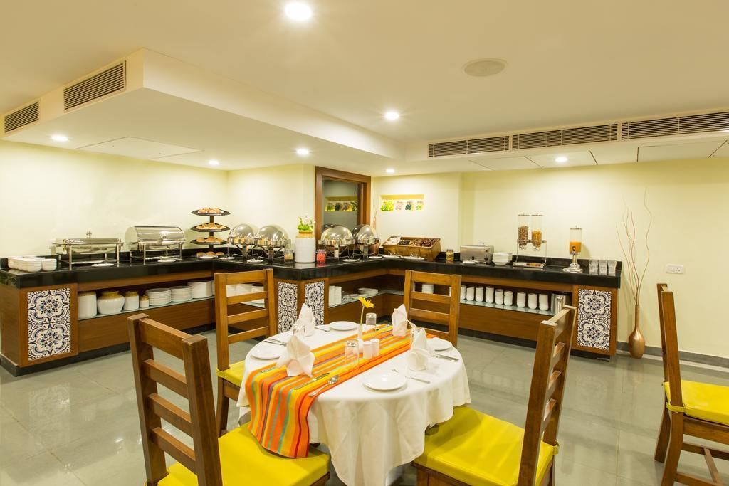 Comedor con barra libre, sillas de madera y una mesa central con mantel blanco.